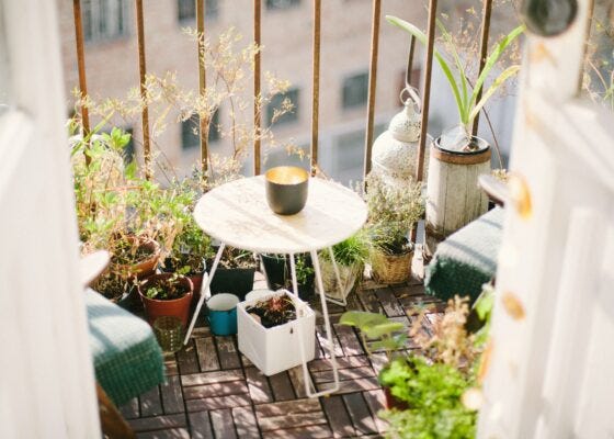 Decoración de terrazas pequeñas con plantas y mesitas auxiliares