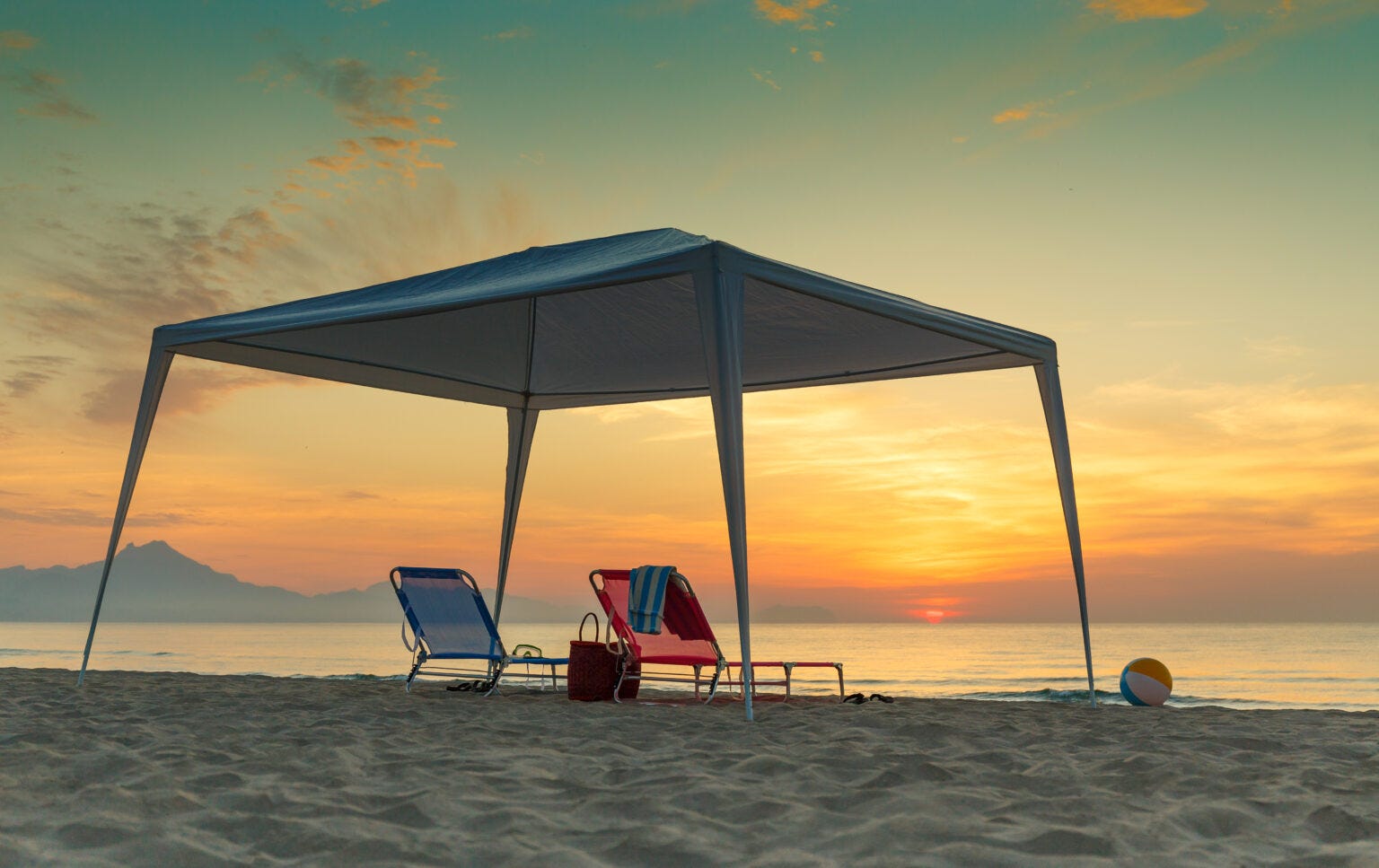 Atardecer en la playa con sillas y gazevo