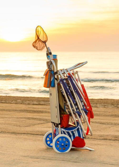 amanecer en la playa con carro portasillas y accesorios