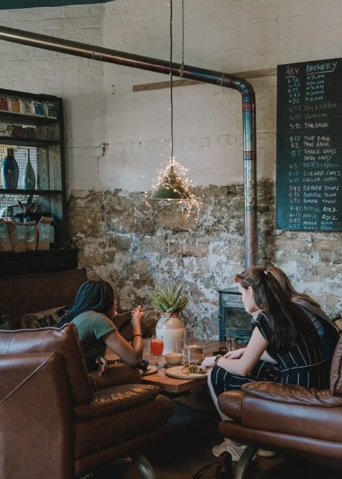 Chicas tomando cafe en una cafeteria de estilo industrial