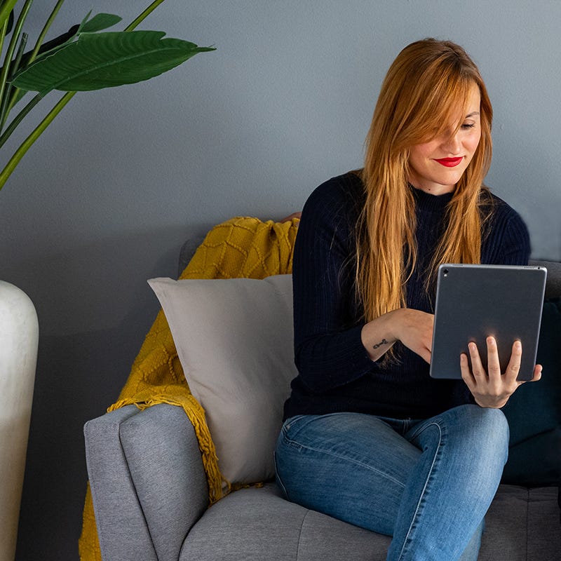 Interiorista con tablet en el sofá