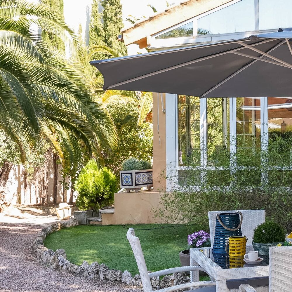 Porche con jardín y faroles en la mesa de comedor