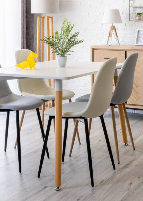 Comedor de estilo nordico con sillas tapizadas en gris y beige