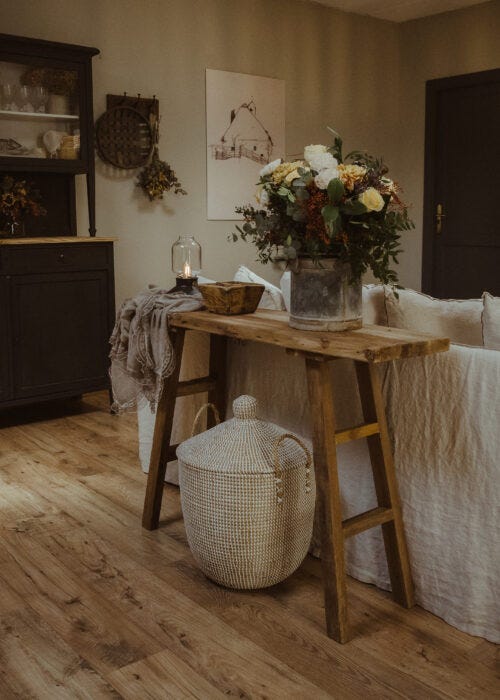 Salón con consola de madera reciclada y elementos decorativos farmhouse