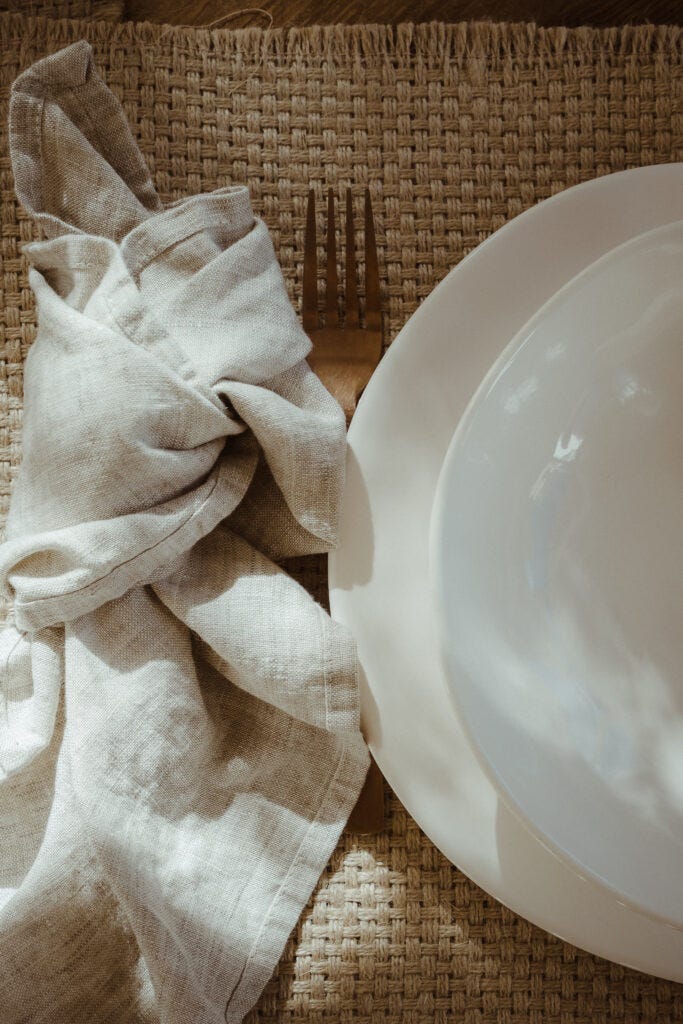detalle de vajilla blanca de porcelana y servilletas de lino