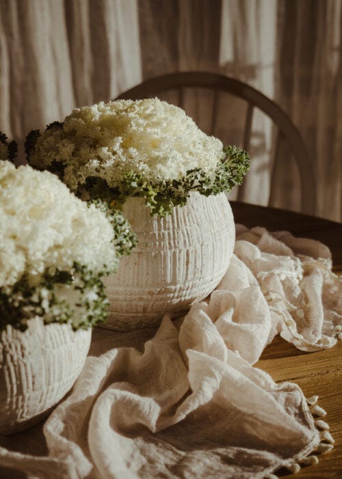 Dos maceteros de efectos envejecido con flores blancas