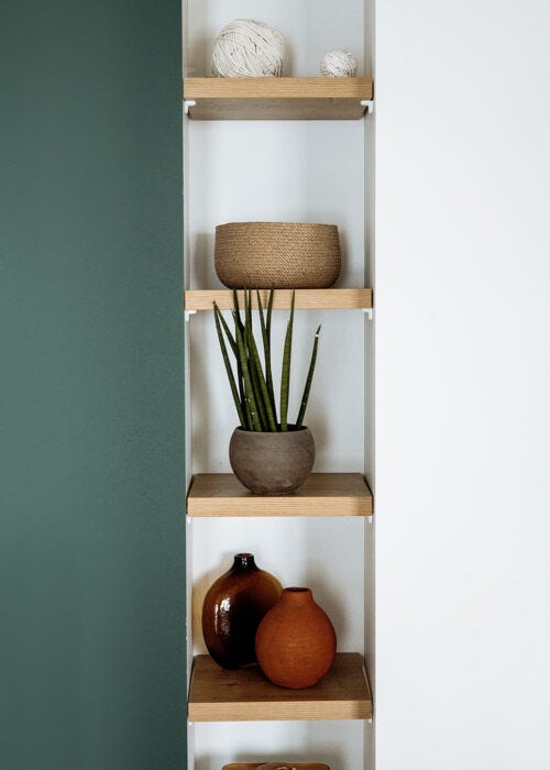 Estantes de madera entre paredes con accesorios decorativos